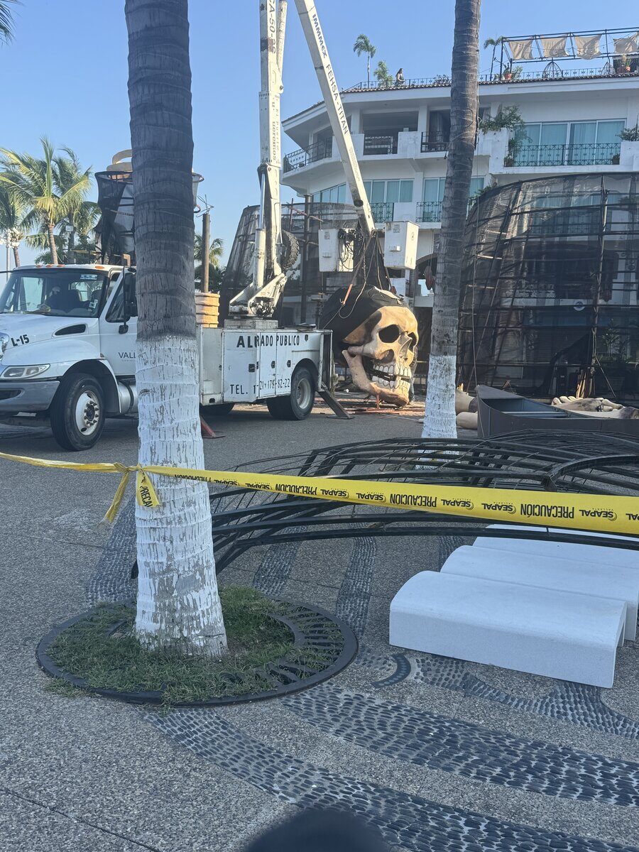 A crane lowering a giant skull into place on the Malecón in Puerto Vallarta