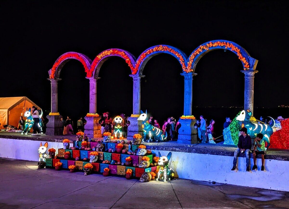 Lit arches and skull figures on the Malecón in Puerto Vallarta at night during Día de los Muertos