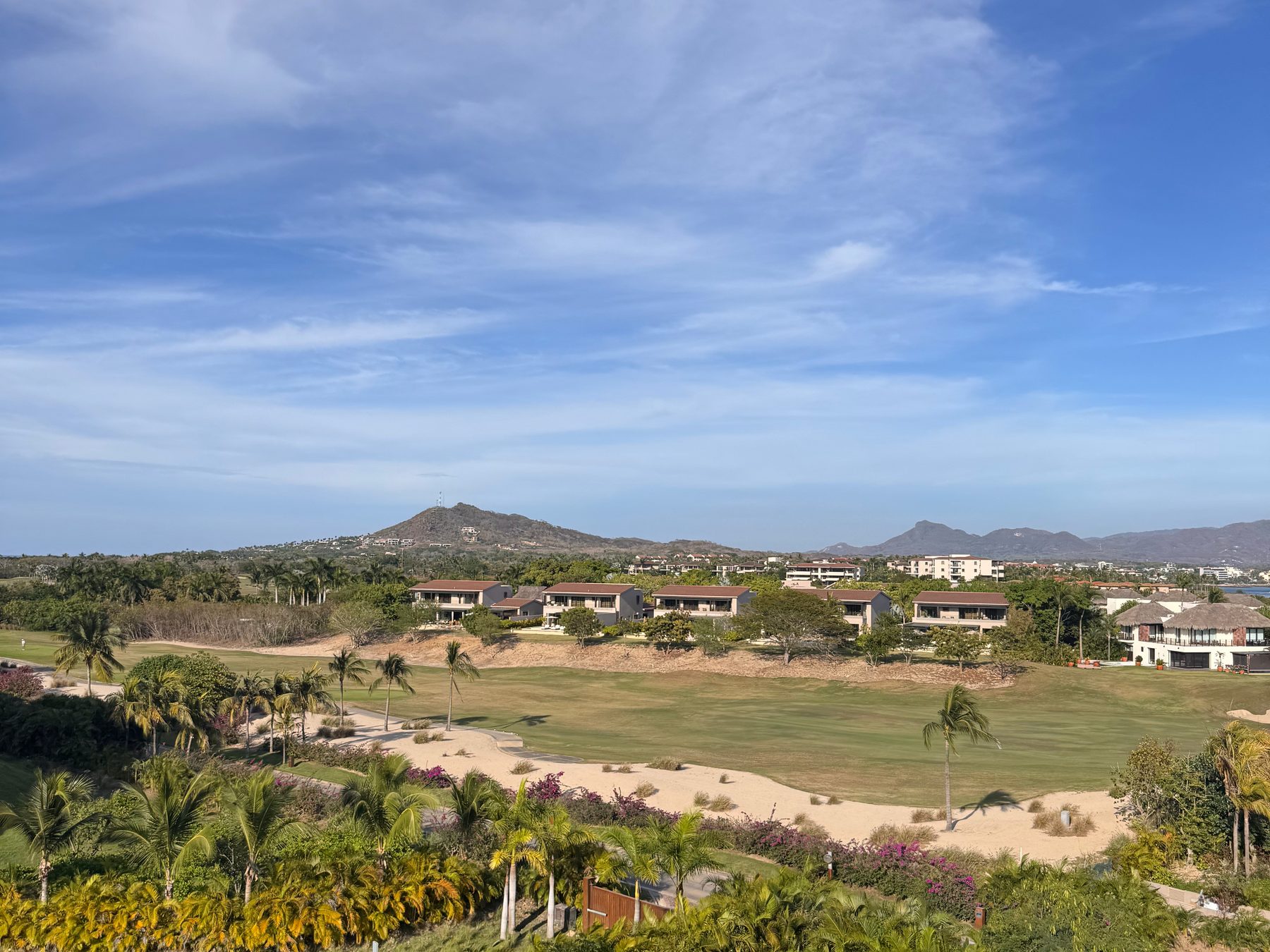 Looking across a Punta Mita golf course and its homes to the hills behind