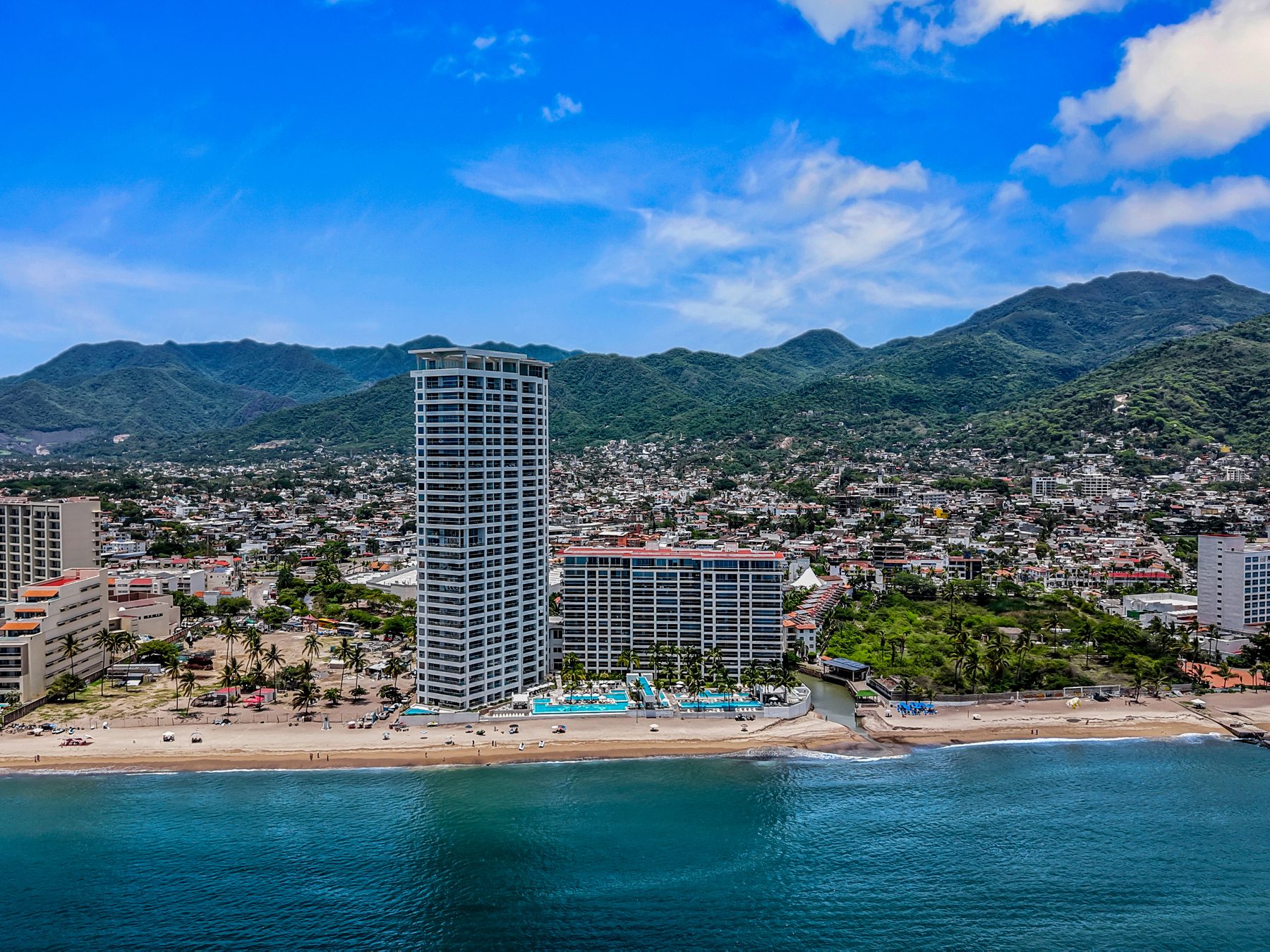 Harbor 171 rising from the beach in the Hotel Zone, with Puerto Vallarta and the Sierra Madre behind it