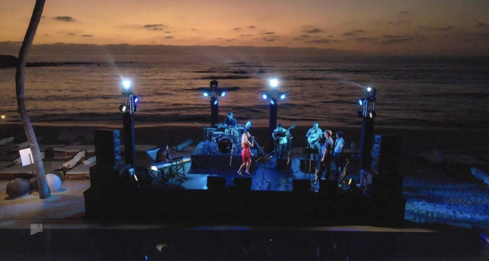 A band performing on the beachfront stage at the Punta Mita Jazz Festival as the sun sets over the Pacific