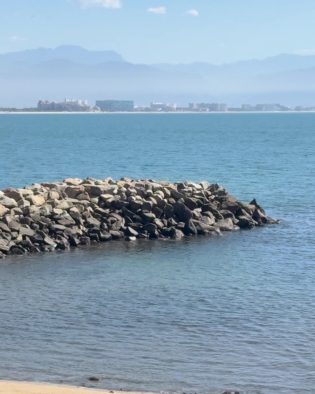 The breakwater and calm water at Punta Esmeralda with Nuevo Nayarit and the mountains across the bay
