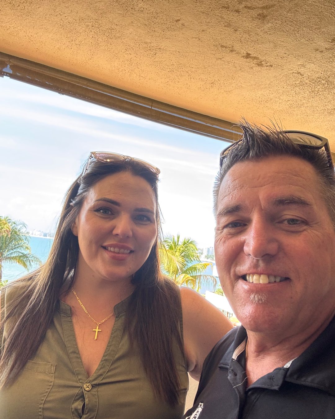 Hannah López and Tom Gordon on a terrace at Punta Esmeralda with the bay behind them