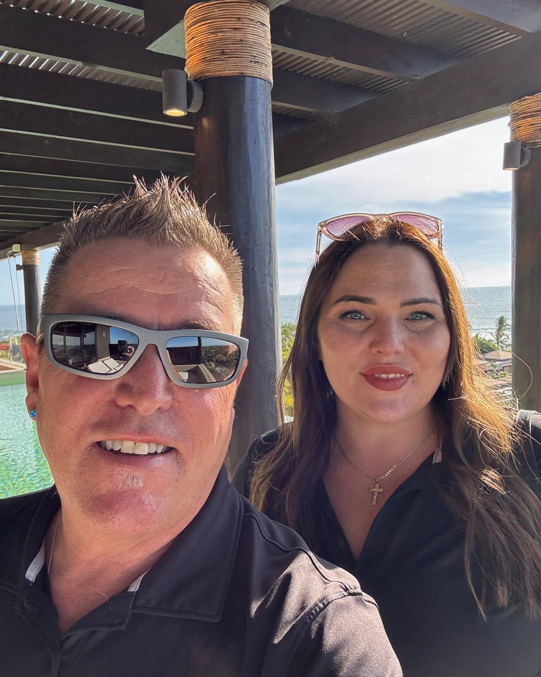 Tom Gordon and Hannah López under a palapa inside Punta Mita with the ocean behind them