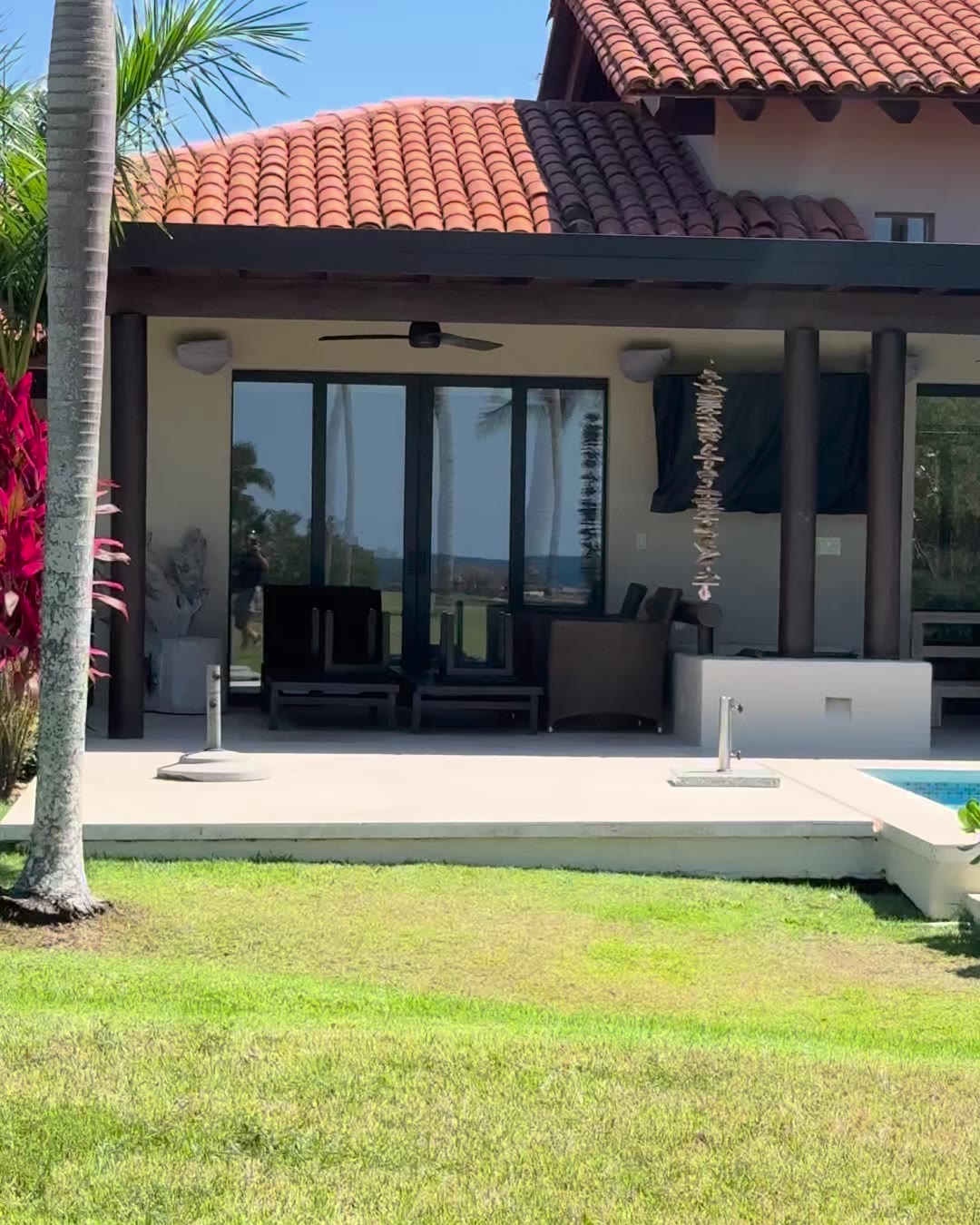 A single-level villa with a tile roof, covered terrace, lawn and pool inside Punta Mita