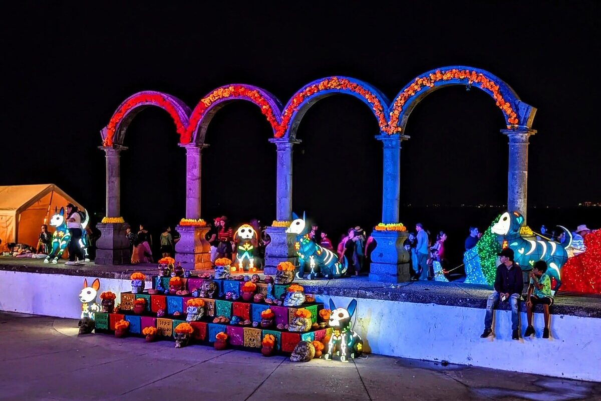 Lit arches and skull figures on the Malecón in Puerto Vallarta at night during Día de los Muertos