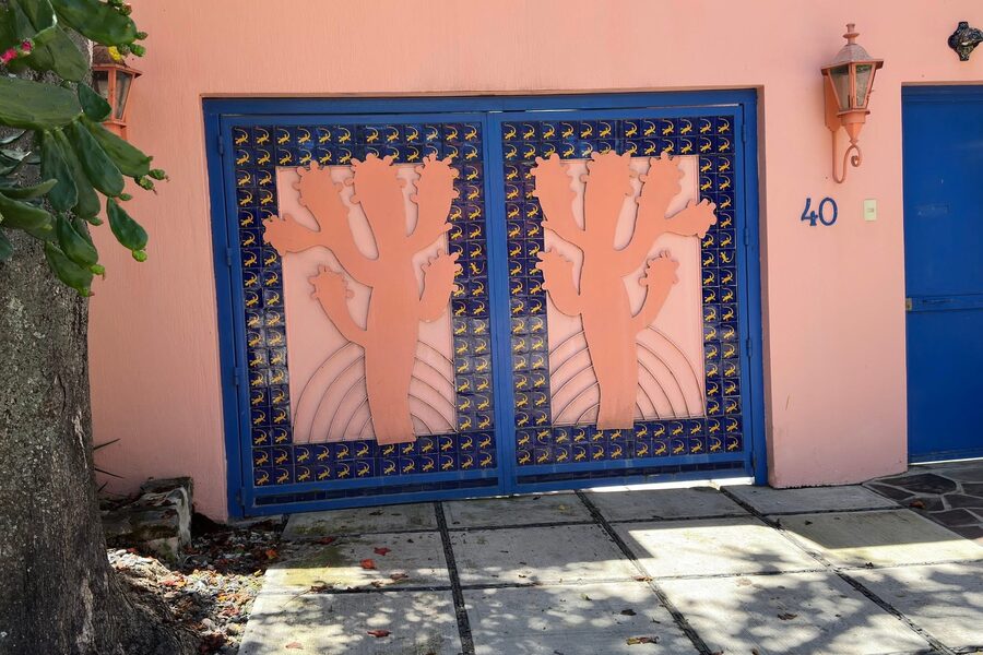 A painted doorway in Puerto Vallarta, pink wall with a blue gate