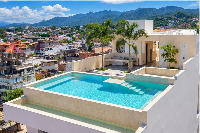 Trópico 1371 rooftop pool with palm trees and the Sierra Madre behind